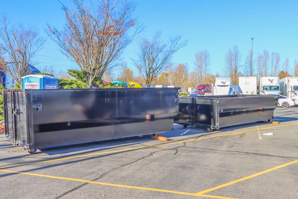 Professional dumpster rental service with roll-off container on residential driveway in Oakfield